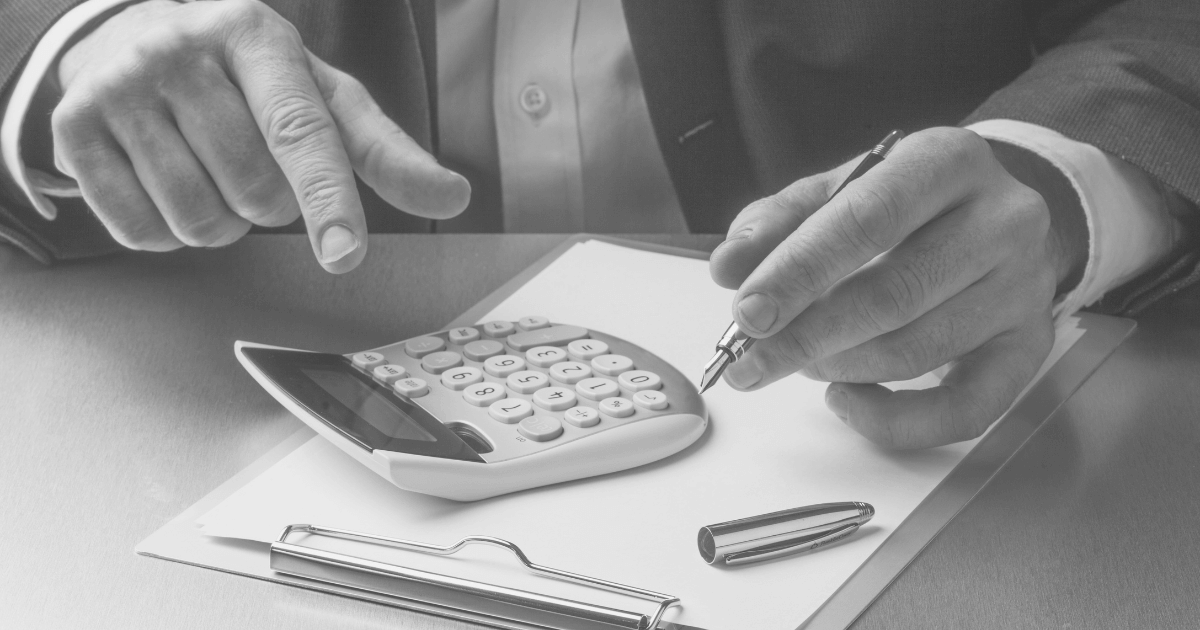 Pessoa de negócios usando calculadora e caneta para planear finanças.
